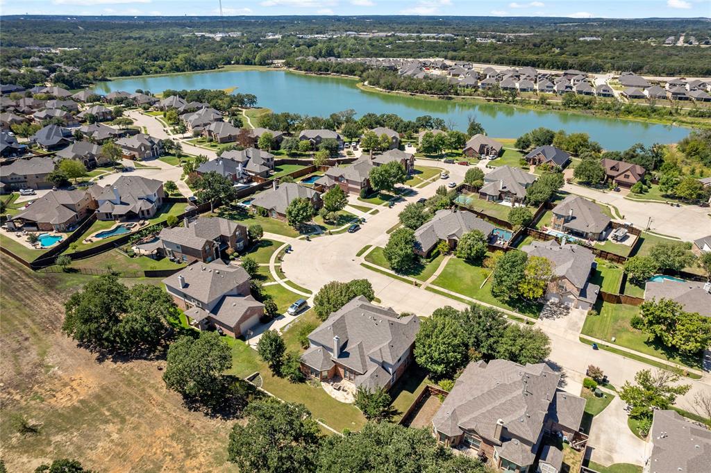 an aerial view of ocean and residential houses with outdoor space