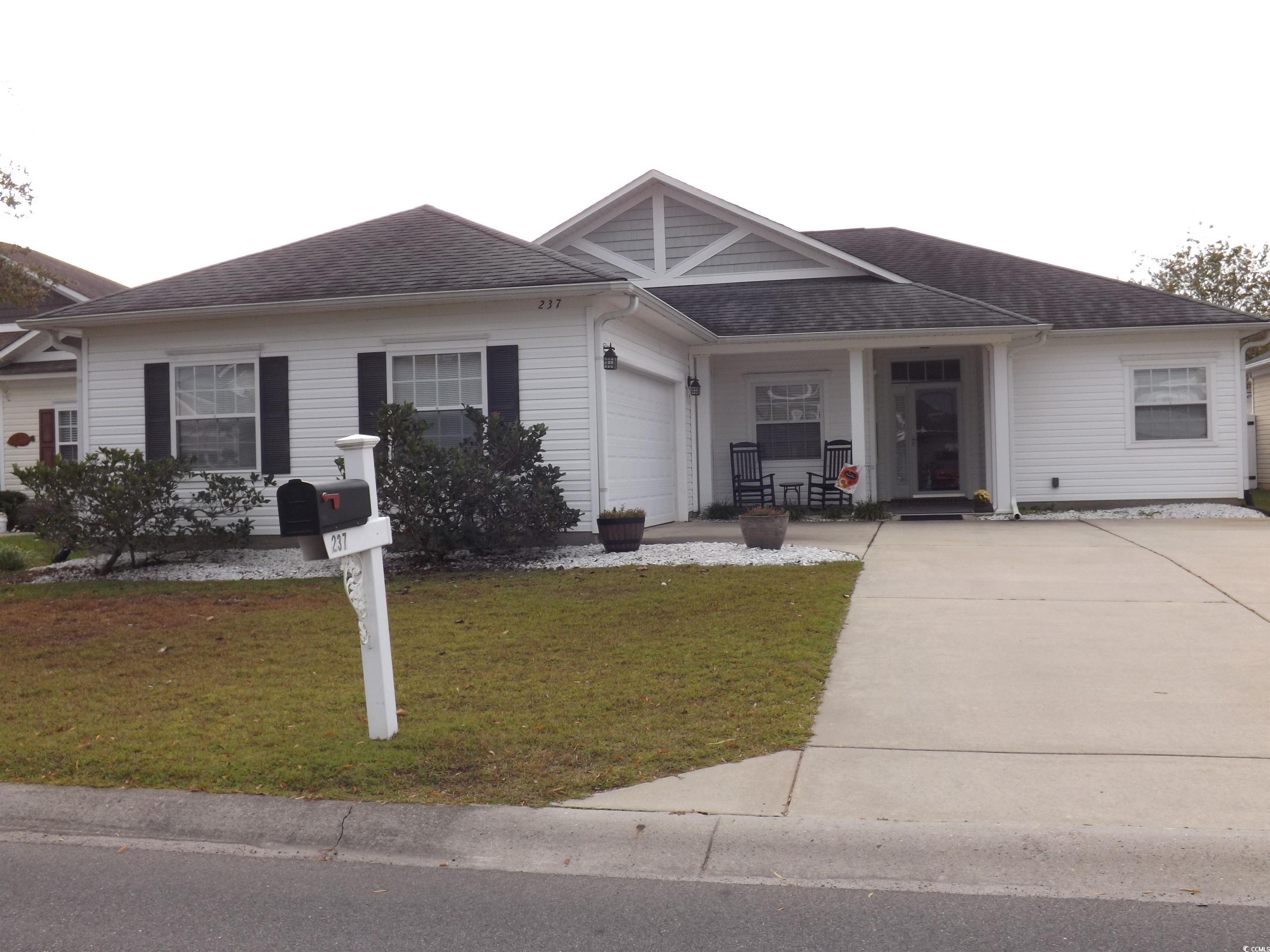 Ranch-style house featuring a front yard and a gar