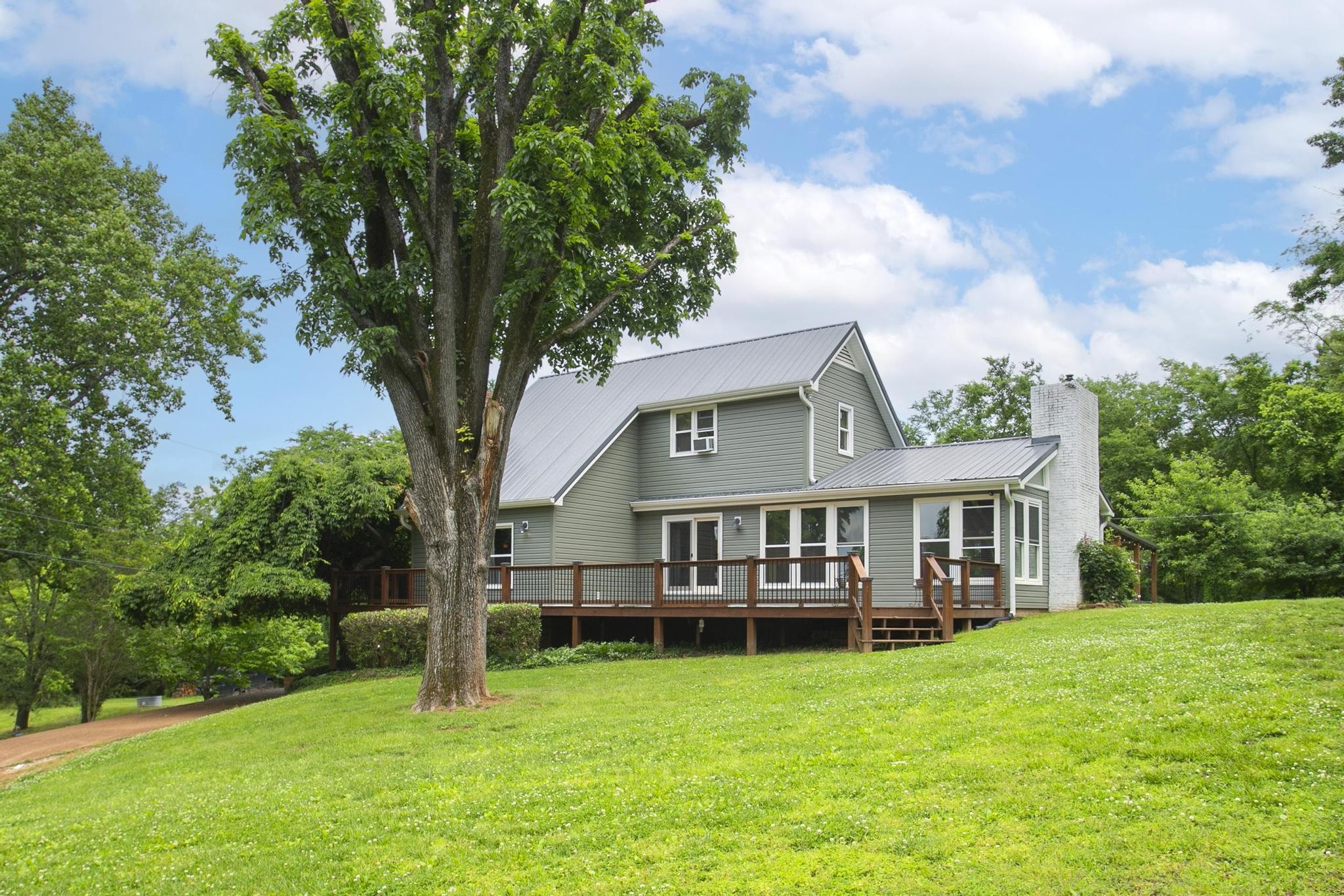 a view of a house with a yard deck and sitting area