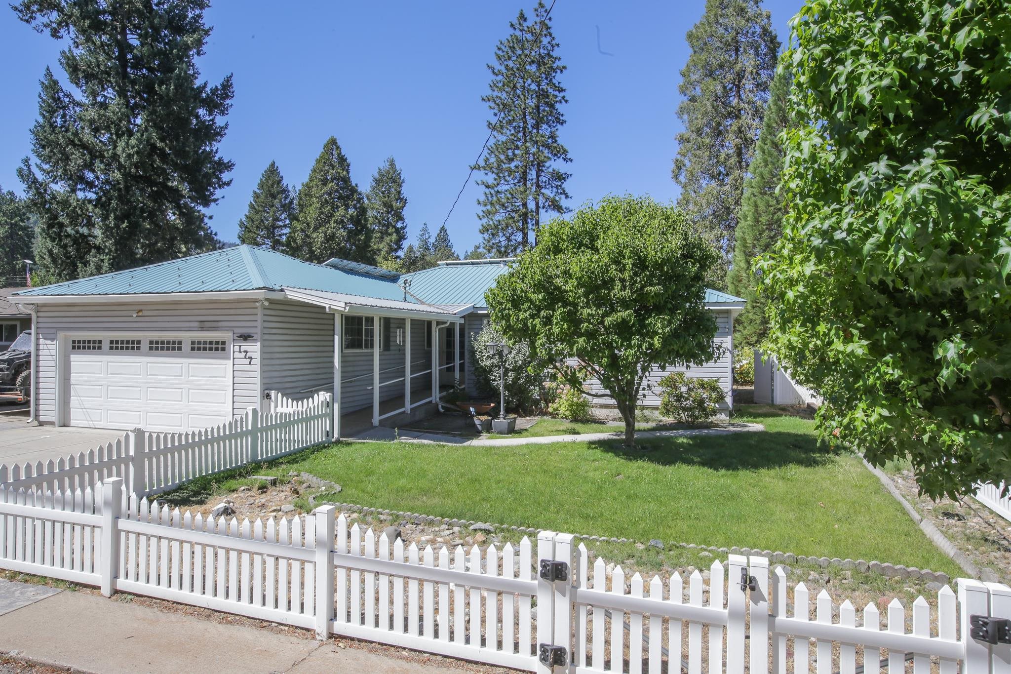 a front view of a house with a garden and trees