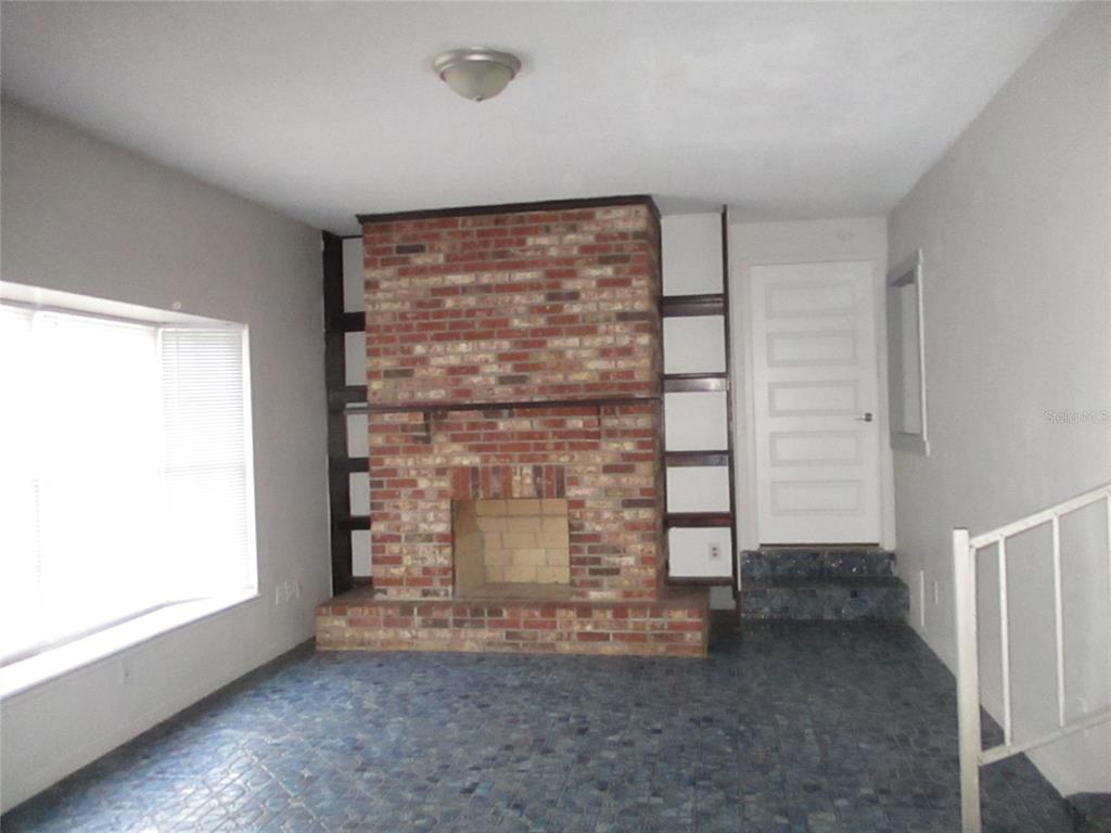 a view of empty room with fireplace and window