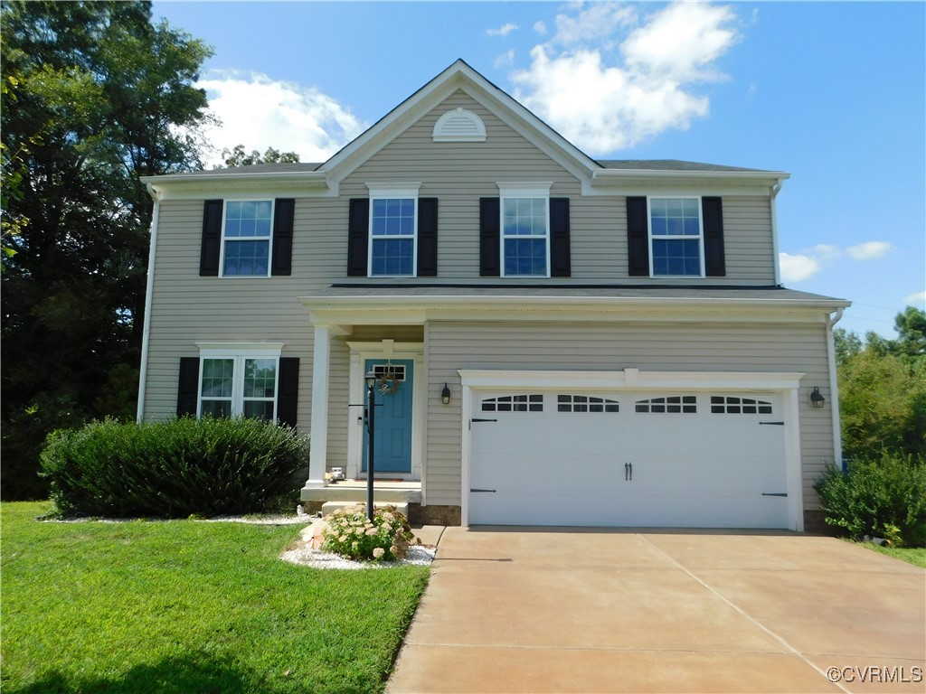 a front view of a house with a yard and garage