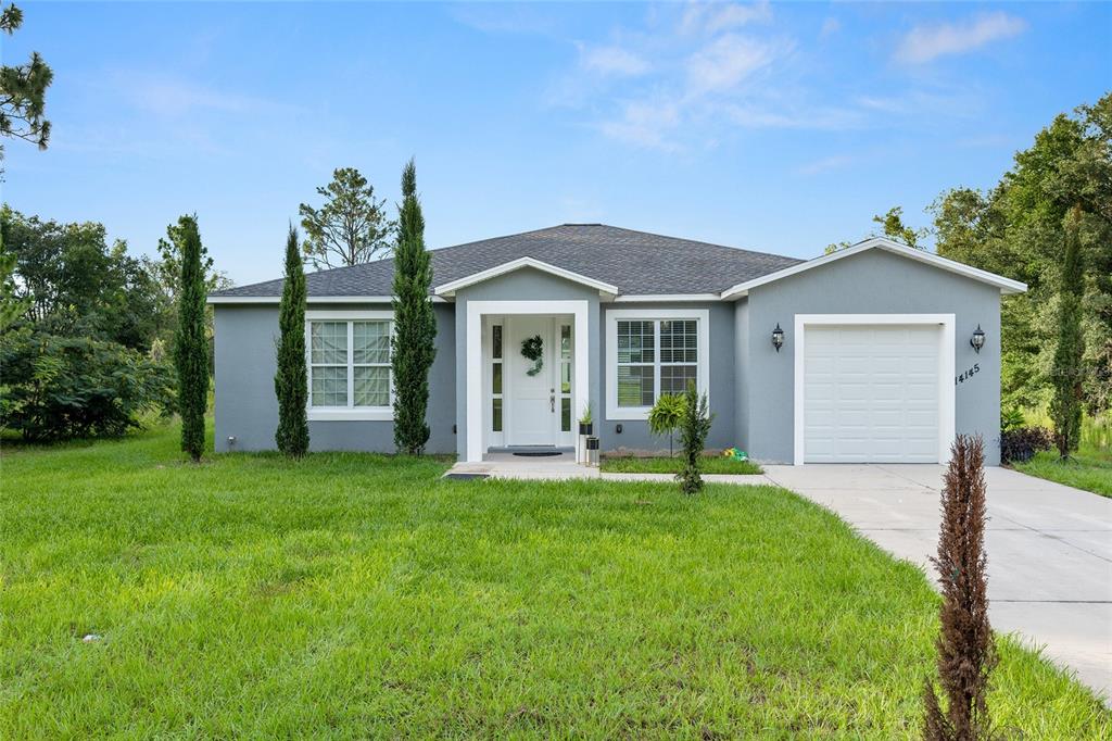 a front view of a house with a garden and yard