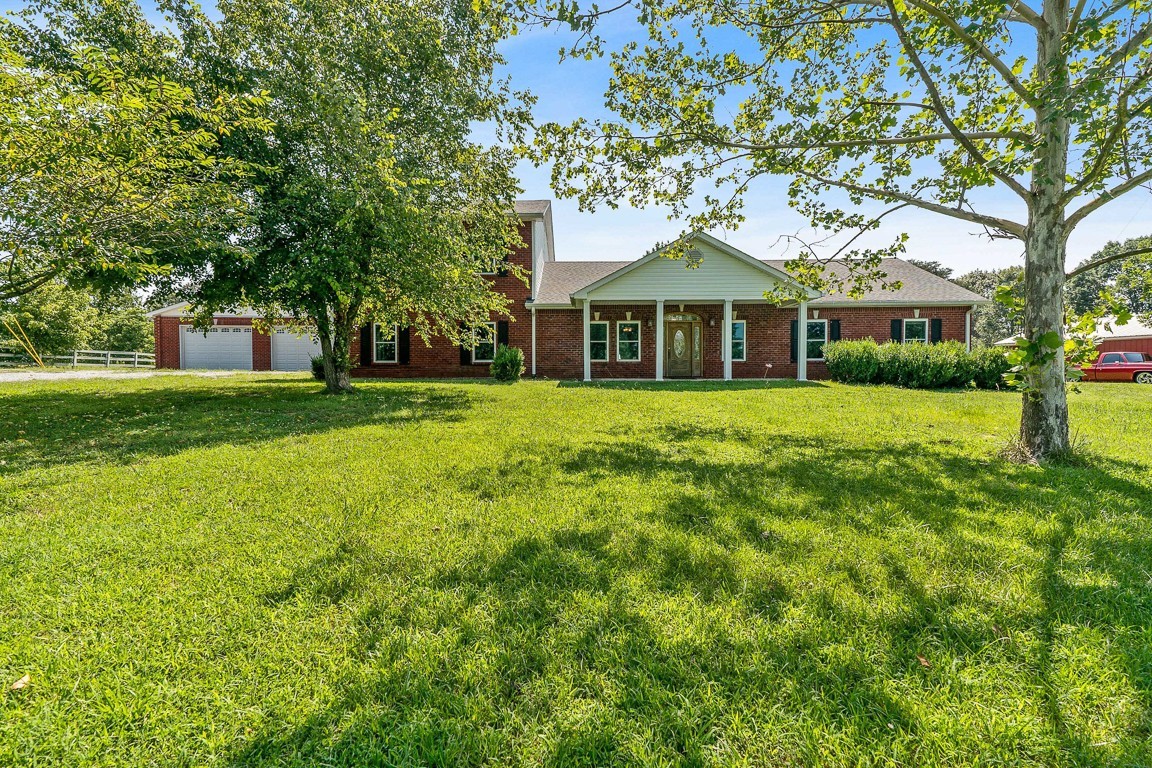 a front view of a house with a yard and trees