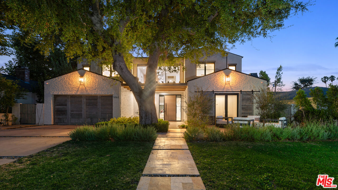 a front view of a house with yard and green space