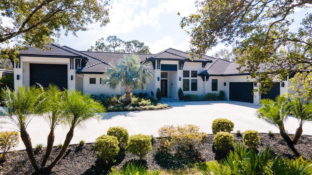 a front view of a house with a yard and a garden