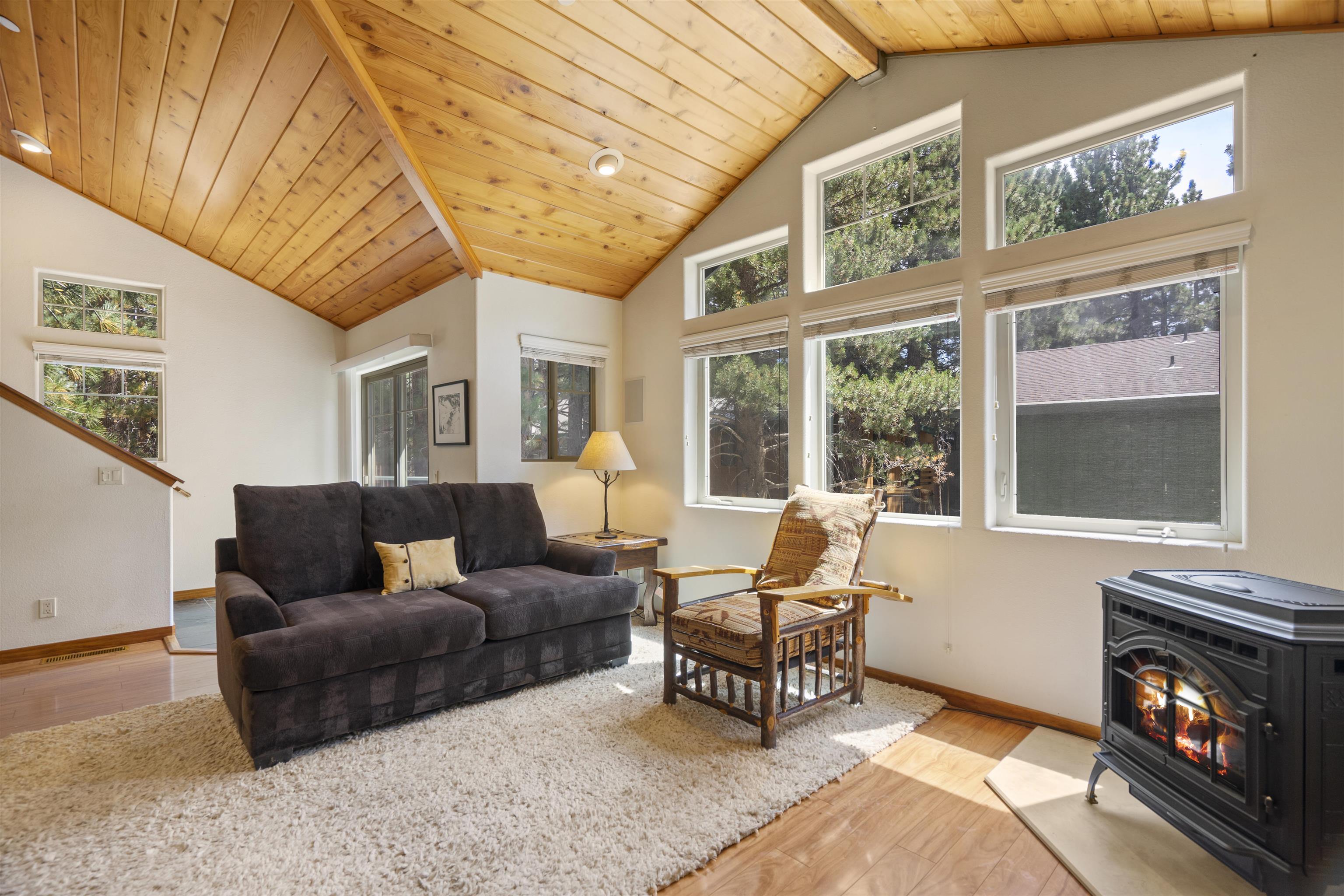 a living room with furniture a fireplace and a floor to ceiling window