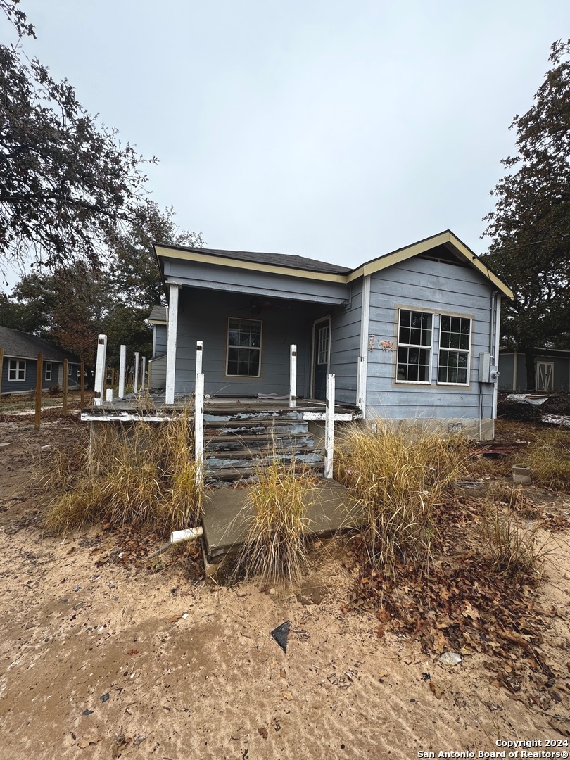 a view of a house with backyard and chairs