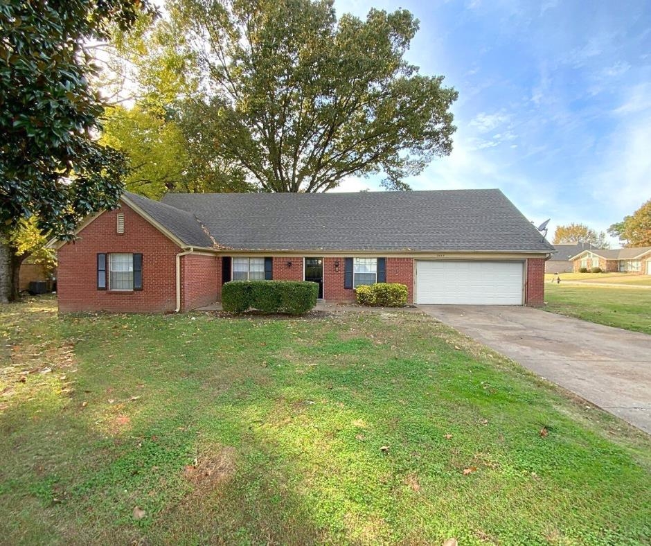 Single story home with a front yard and a garage