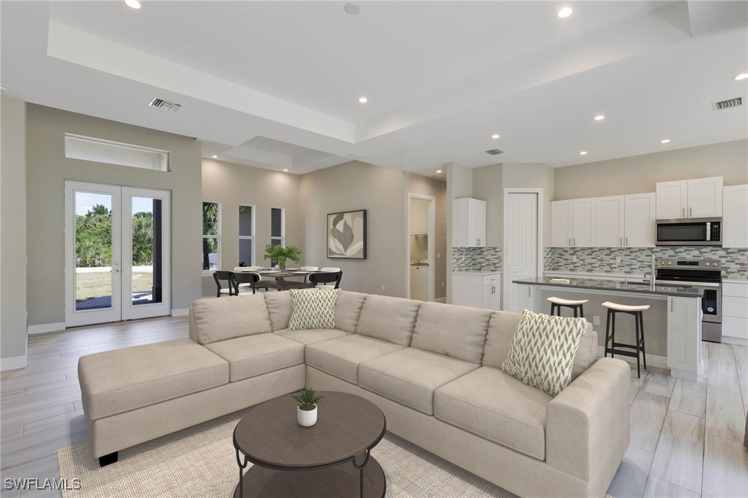 a living room with furniture and view of kitchen