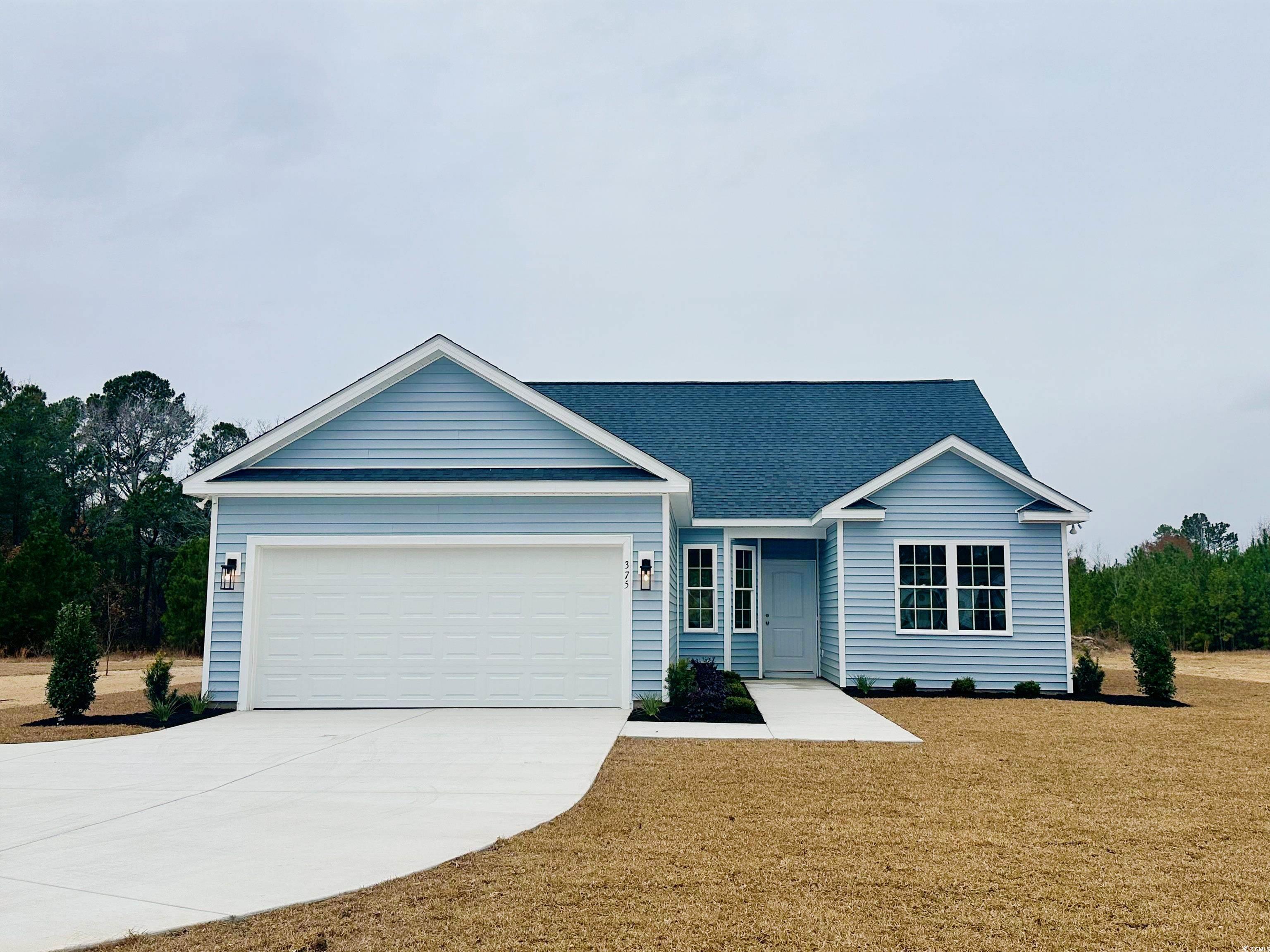 Single story home featuring a front yard and a gar