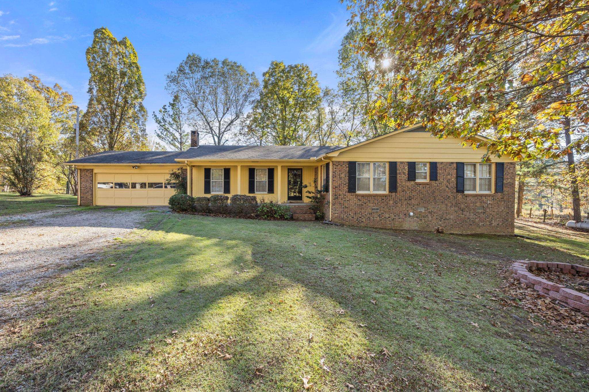 Single story home with a garage and a front yard