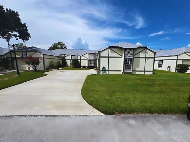 a view of a house with a big yard and large trees