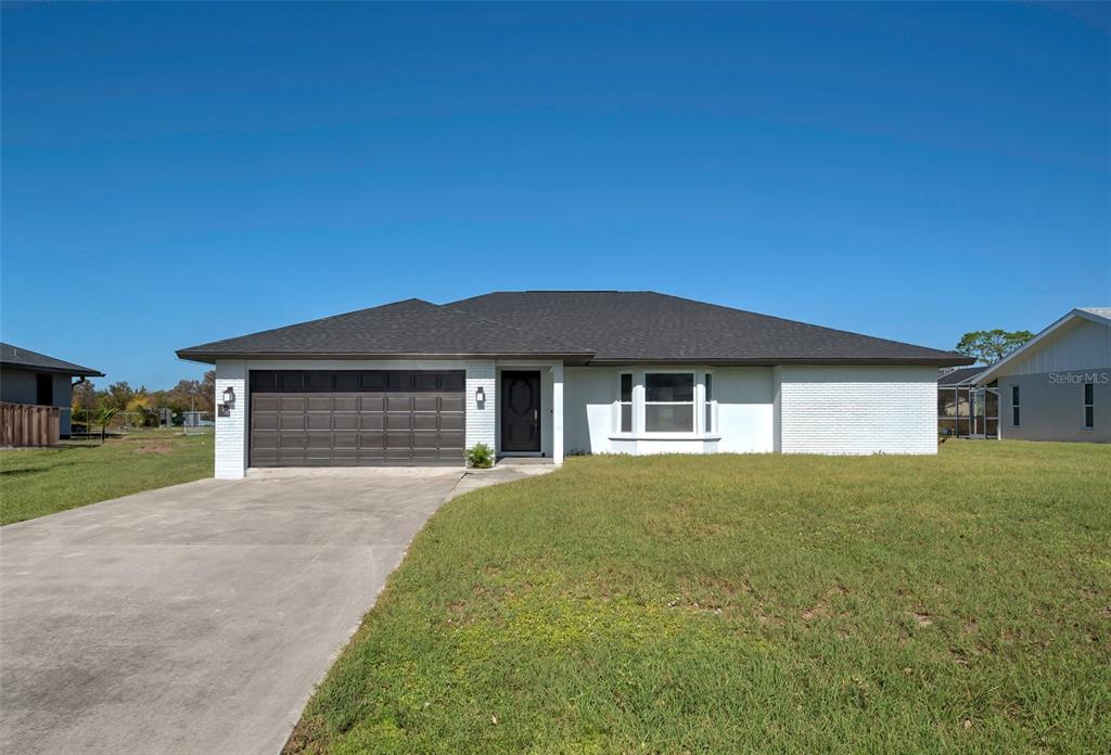 a front view of a house with yard and garage