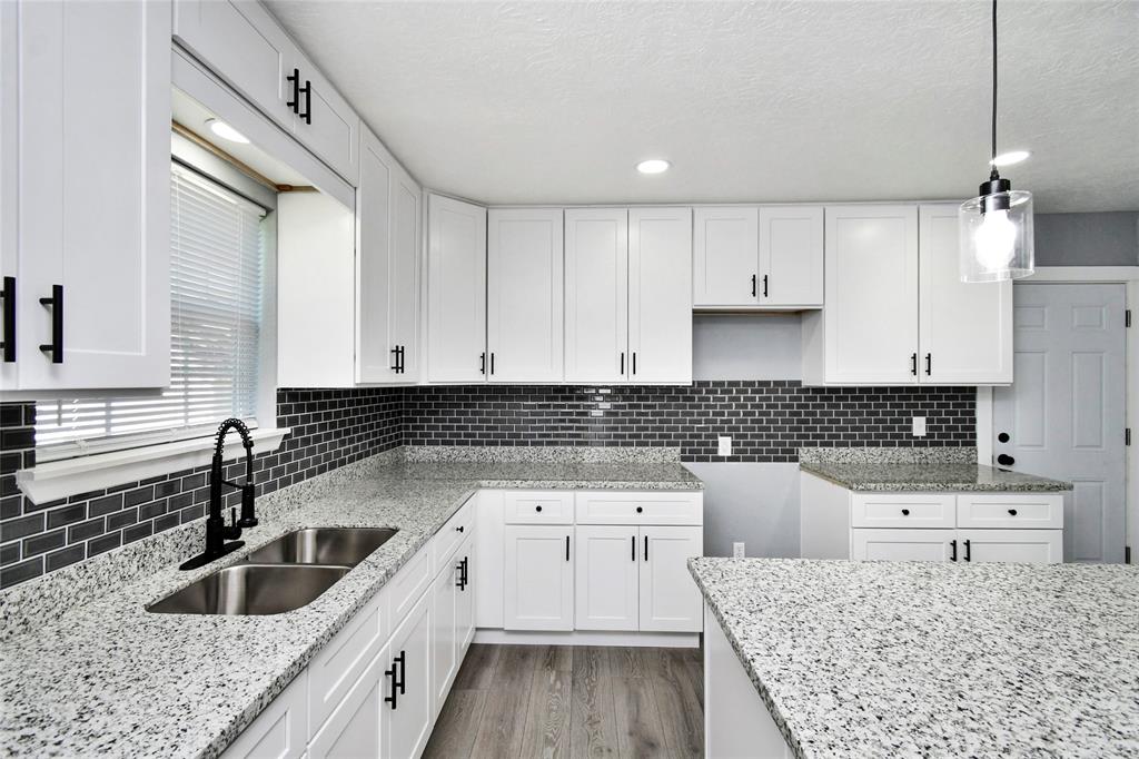 a kitchen with a sink stove and cabinets