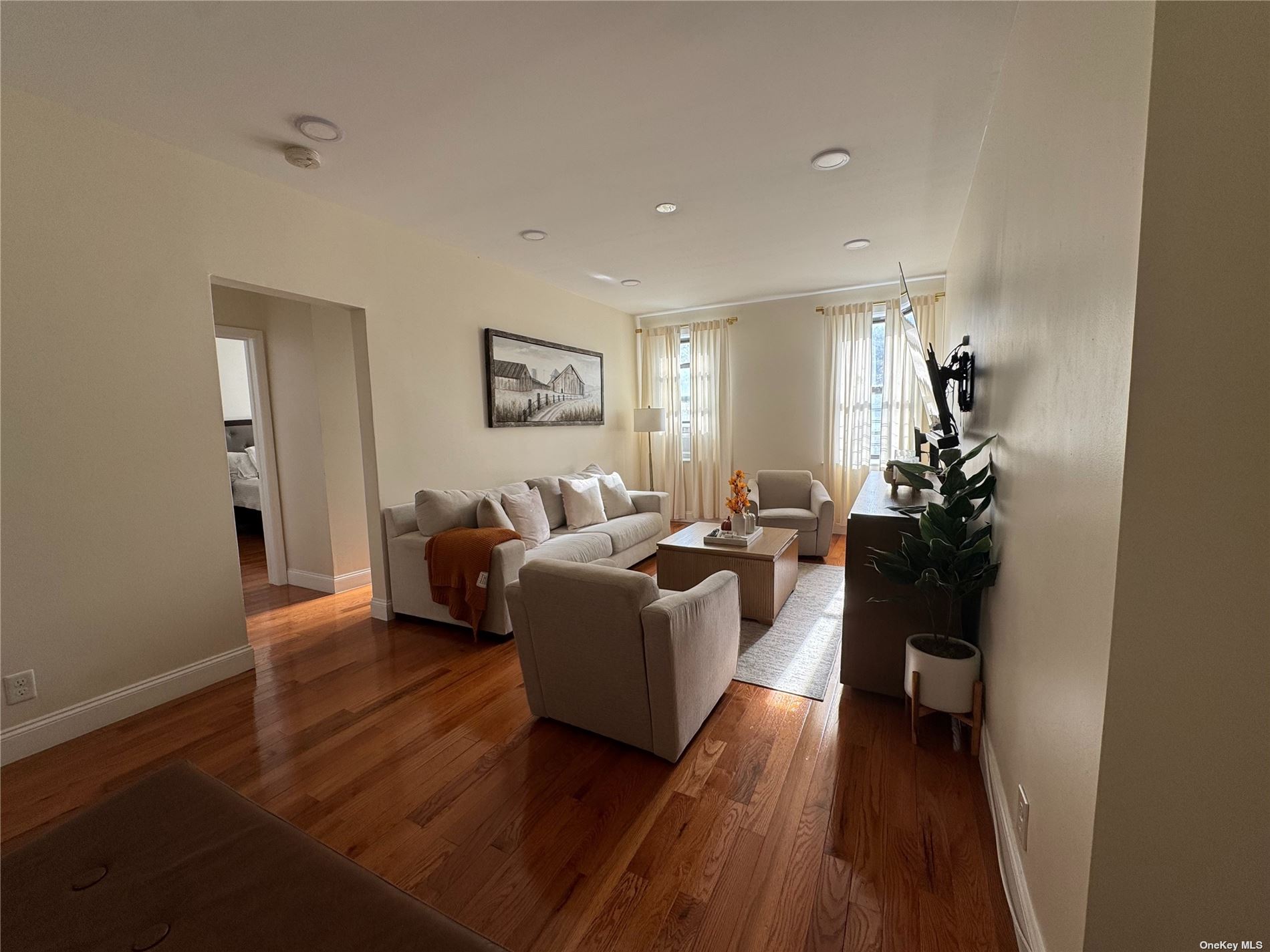 a living room with furniture and a wooden floor