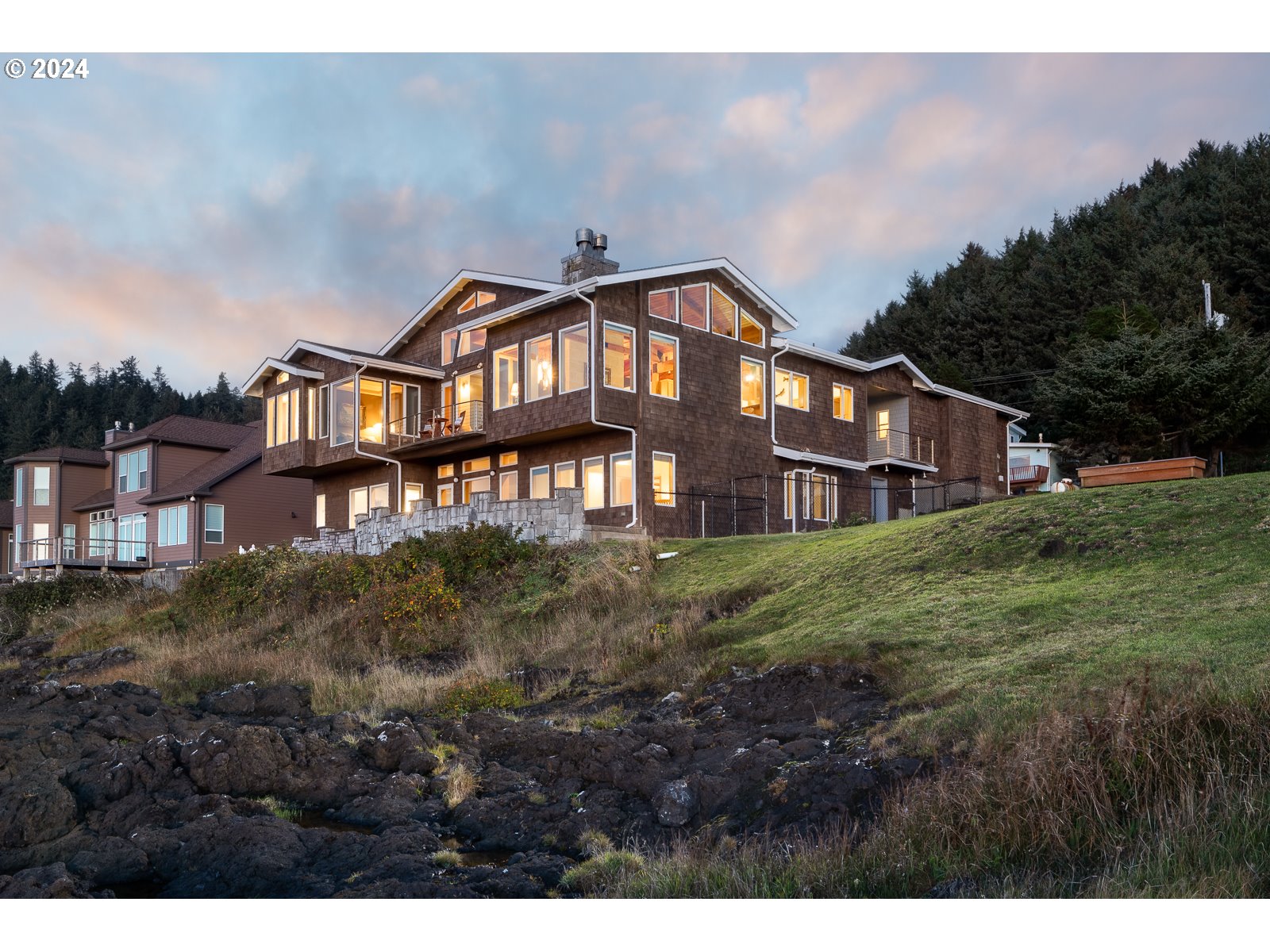 a view of a big house with a big yard and large trees