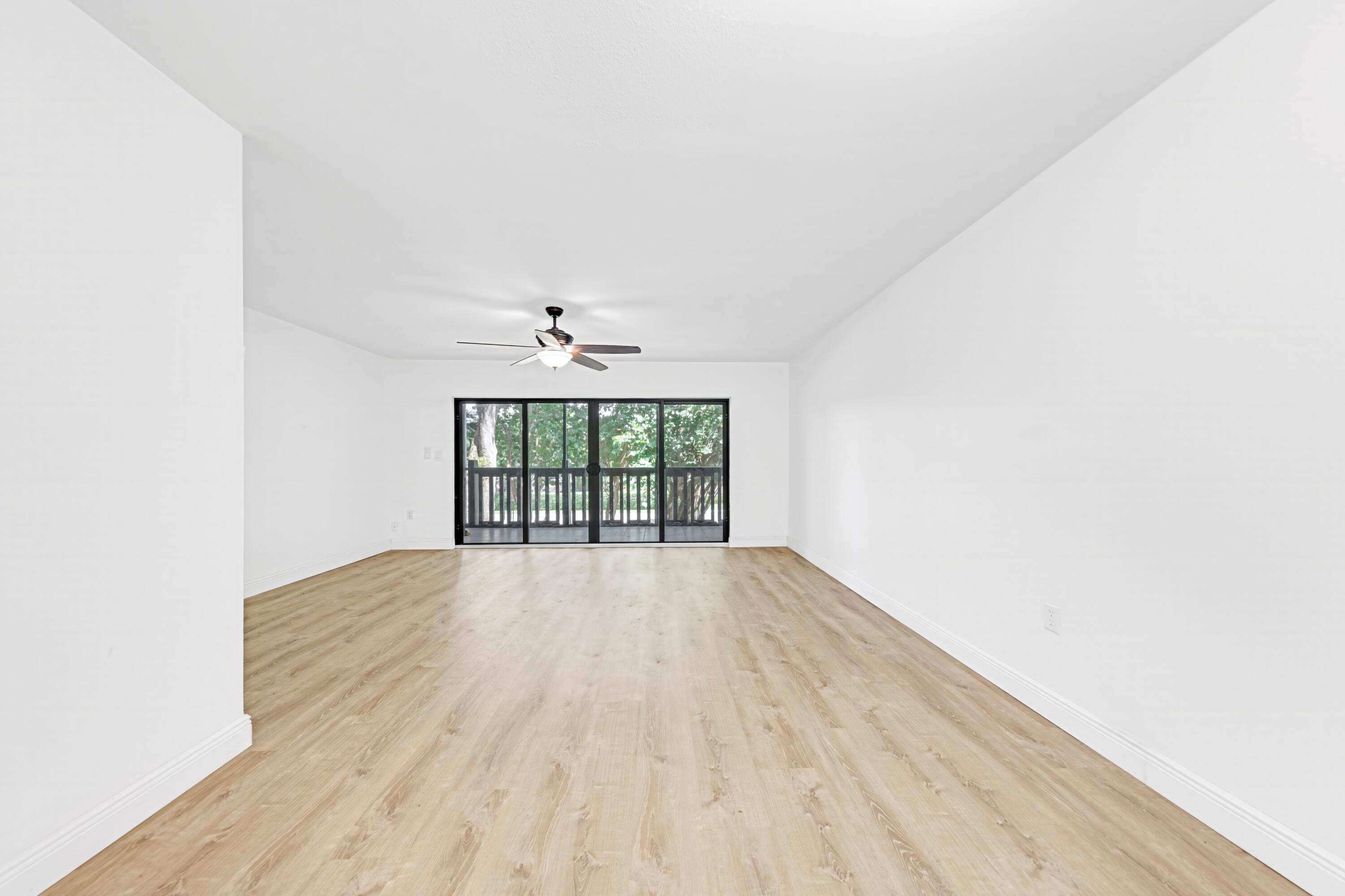 an empty room with wooden floor and chandelier