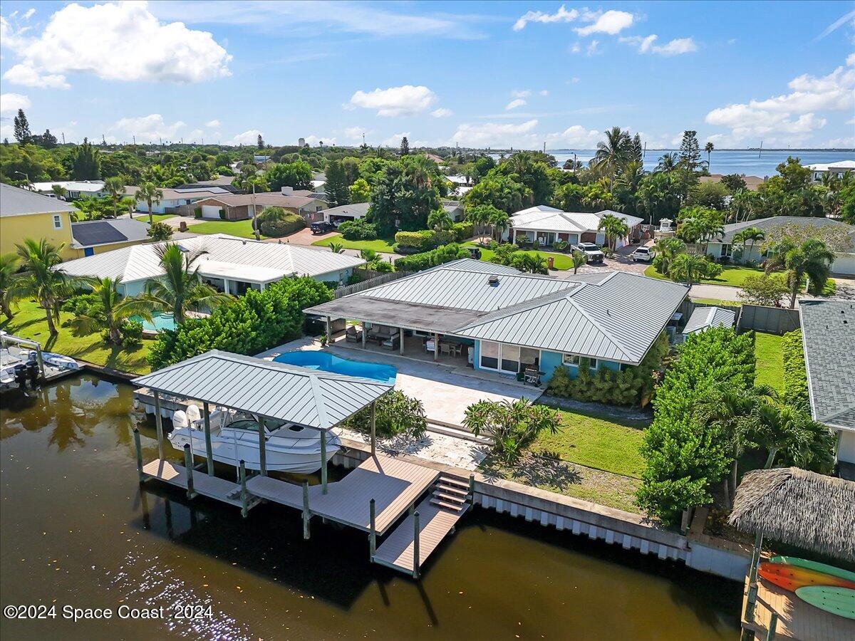 an aerial view of a house with swimming pool patio and lake view