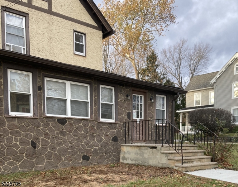 a front view of a house with a tree