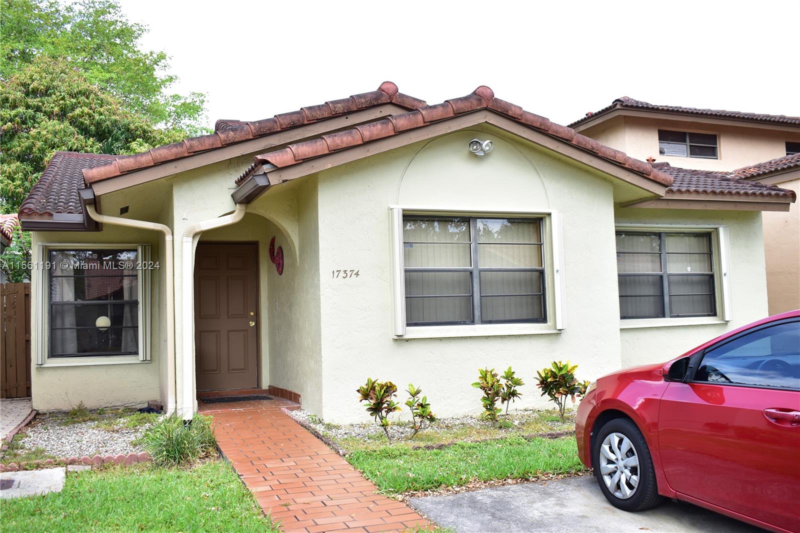 a front view of a house with a garden and plants