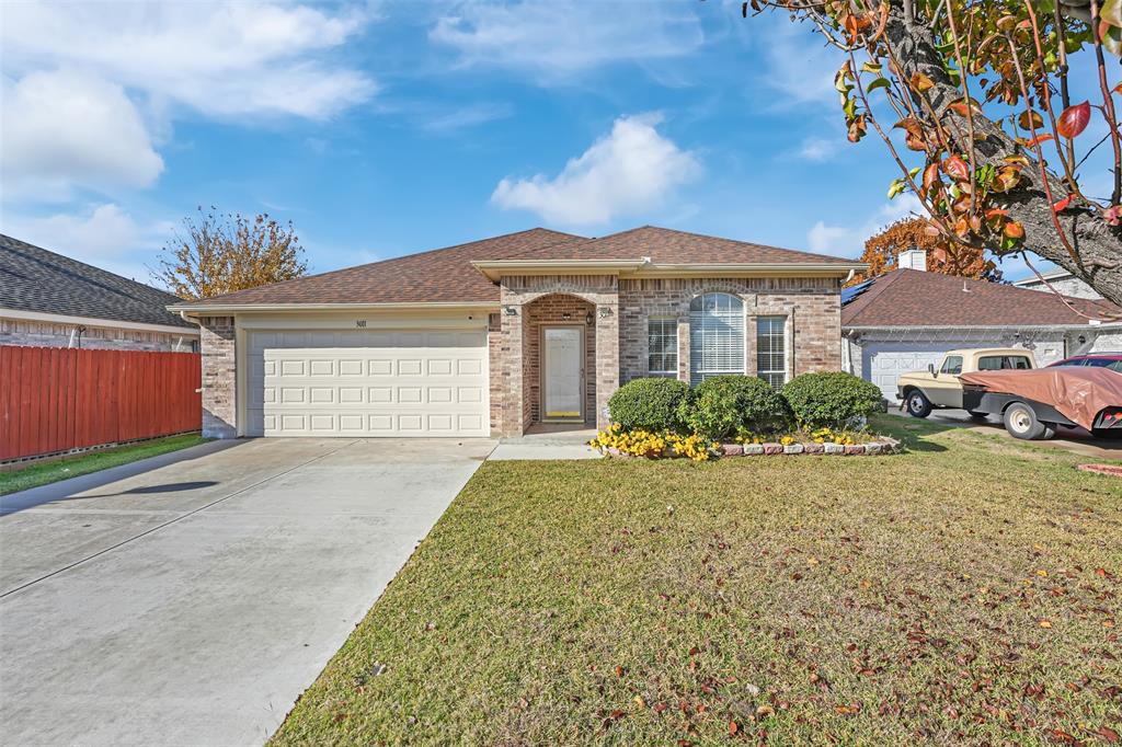 View of front of home with a front yard and a garage