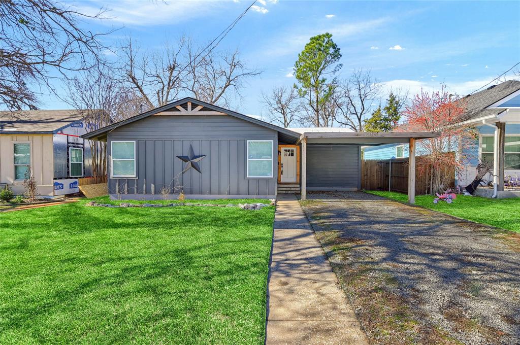 Single story home featuring a front yard and a carport