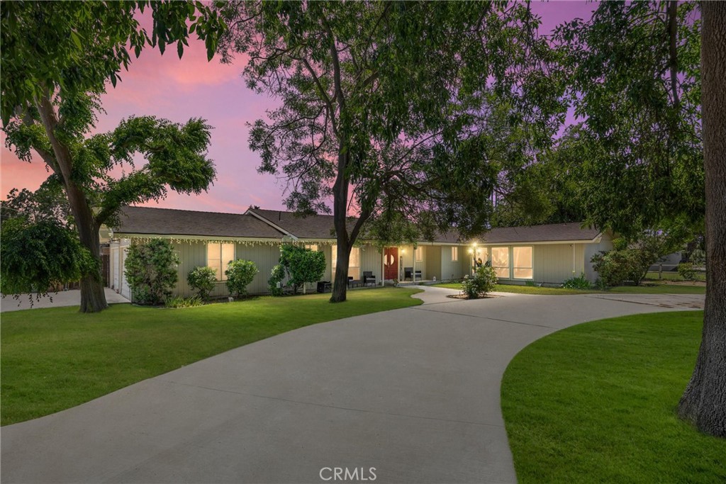 a view of a house with a yard and tree s