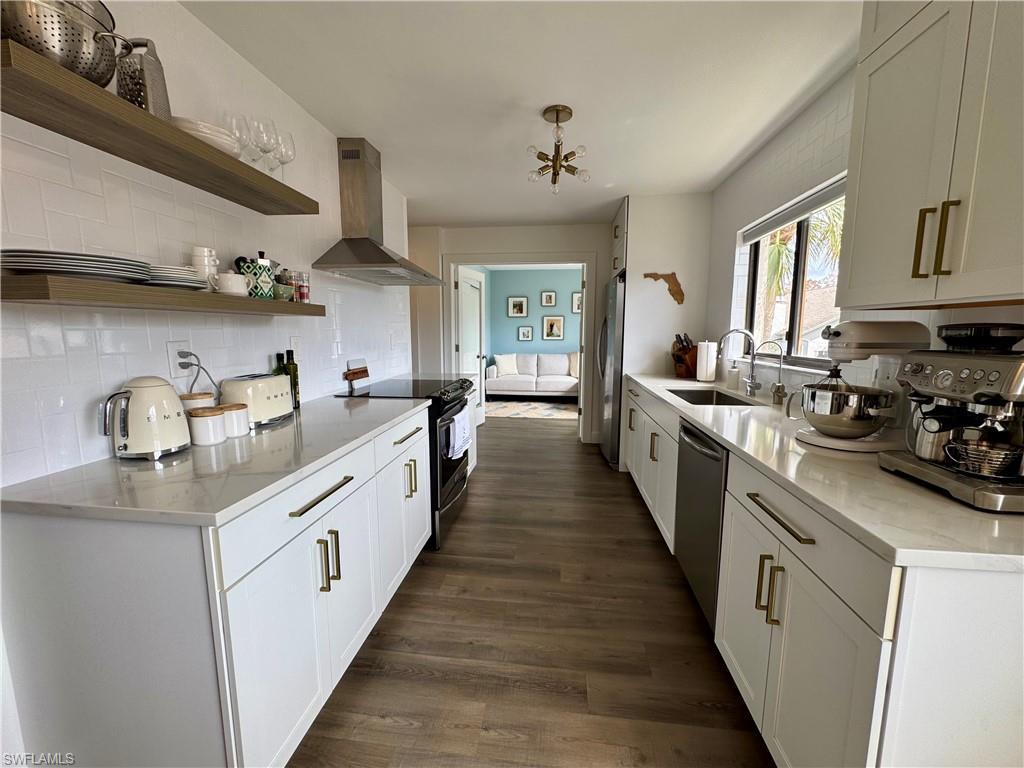 a large kitchen with stainless steel appliances lots of counter space and wooden floor