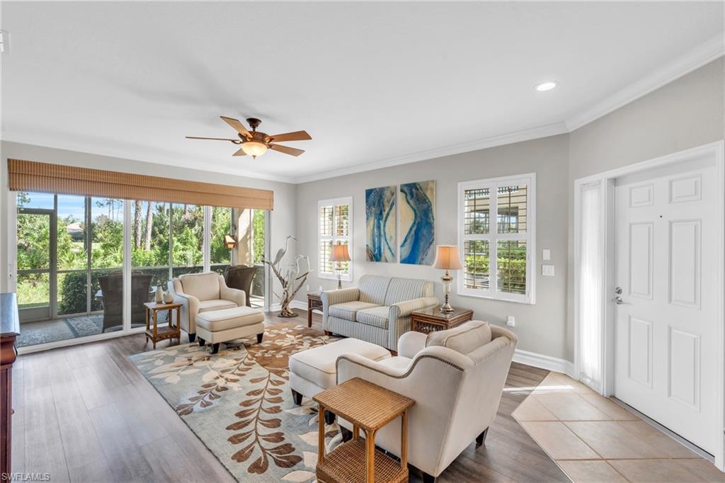 a living room with furniture and a large window with balcony view