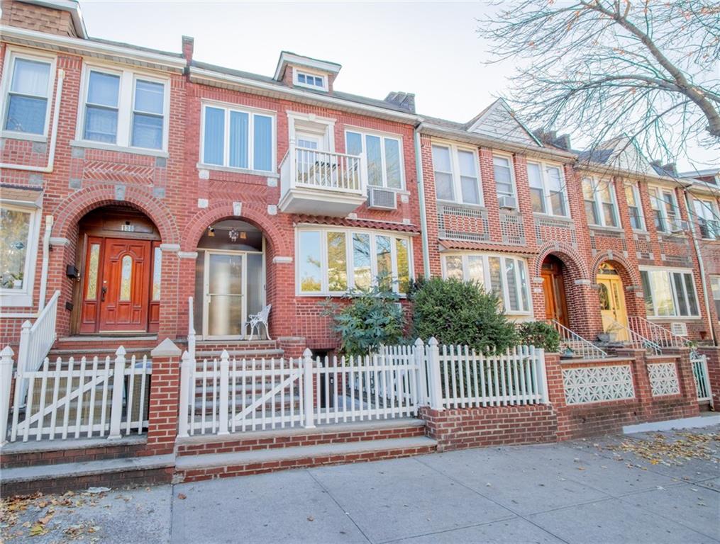 front view of a brick house with a fence