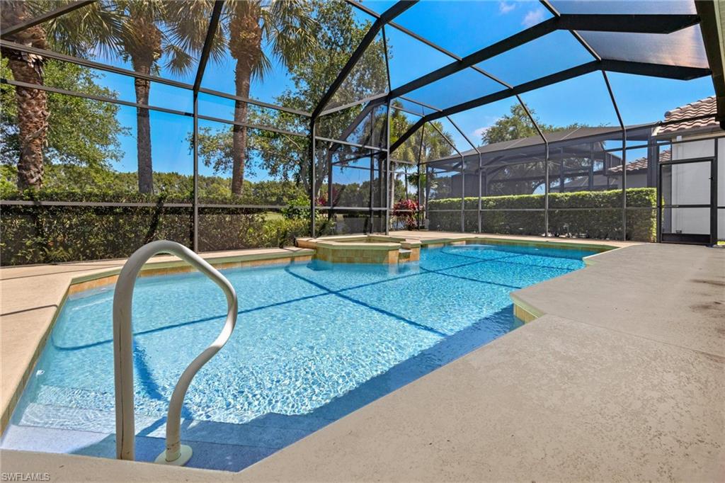 a view of a swimming pool with a patio and wooden fence