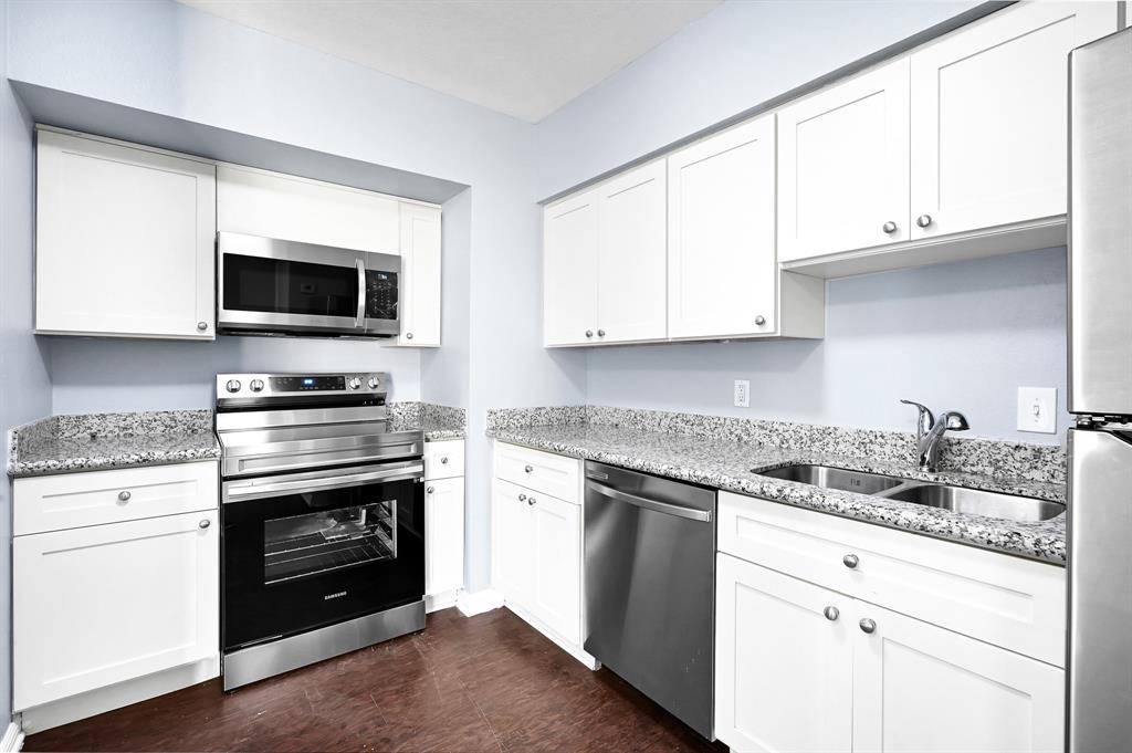 a kitchen with granite countertop a stove and a microwave