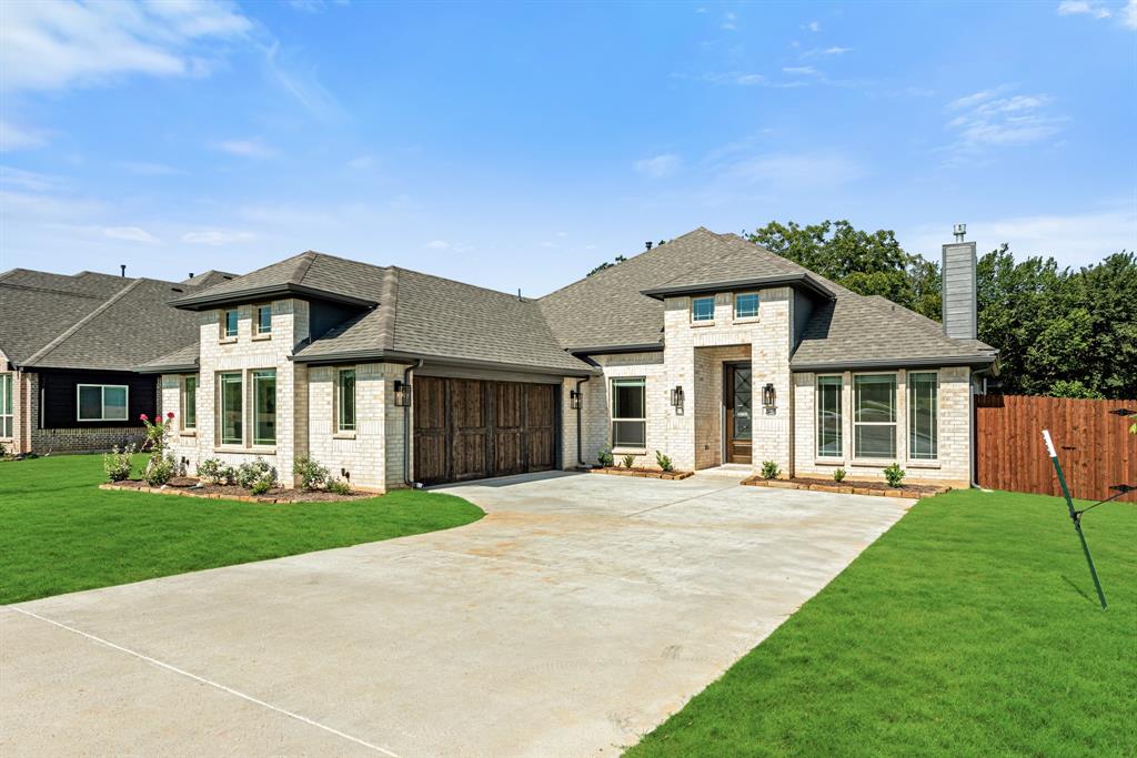 a front view of a house with a garden and yard