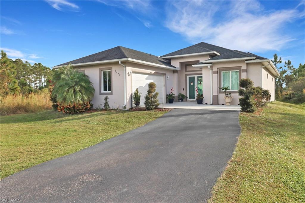 View of front facade featuring a front lawn and a garage