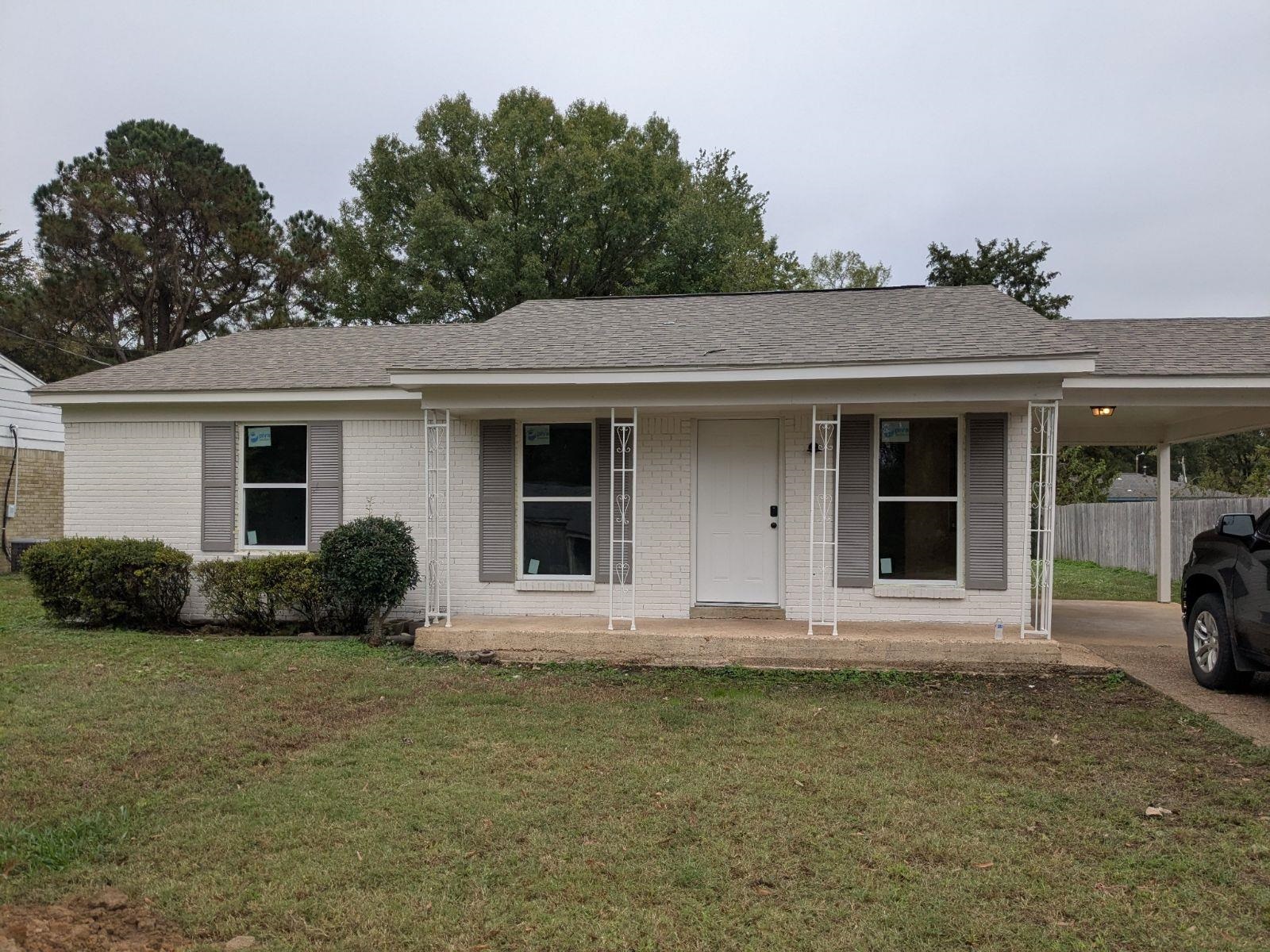 Single story home with a front lawn and covered porch