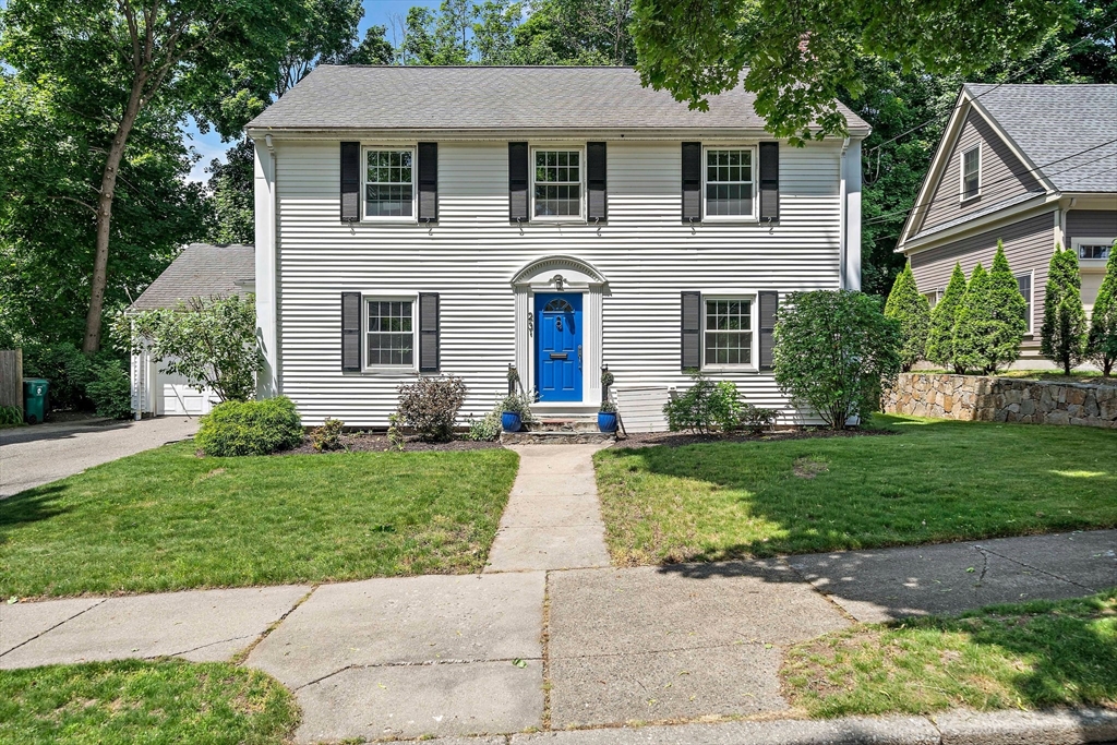 a front view of a house with a yard and trees