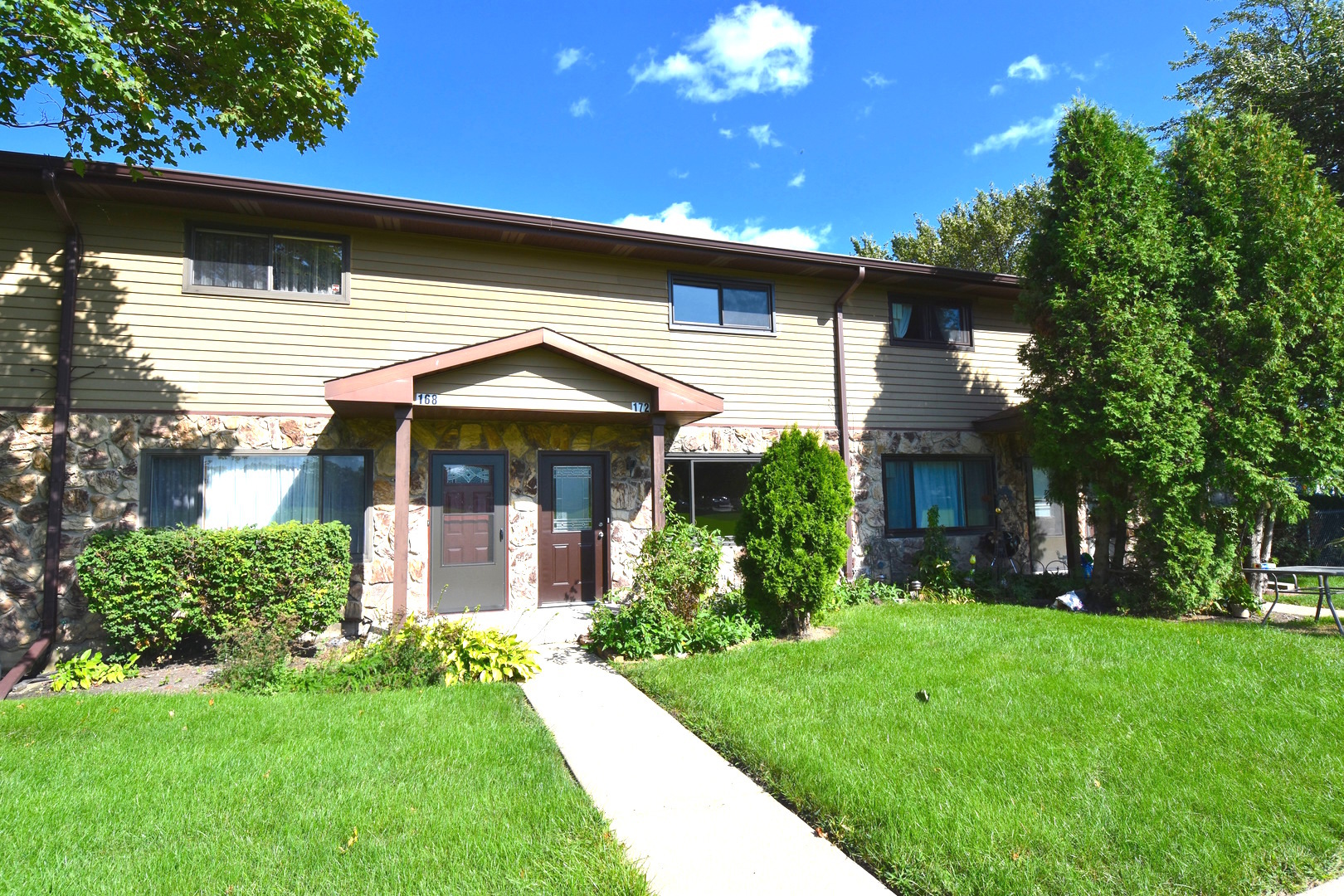 a front view of a house with a yard and potted plants