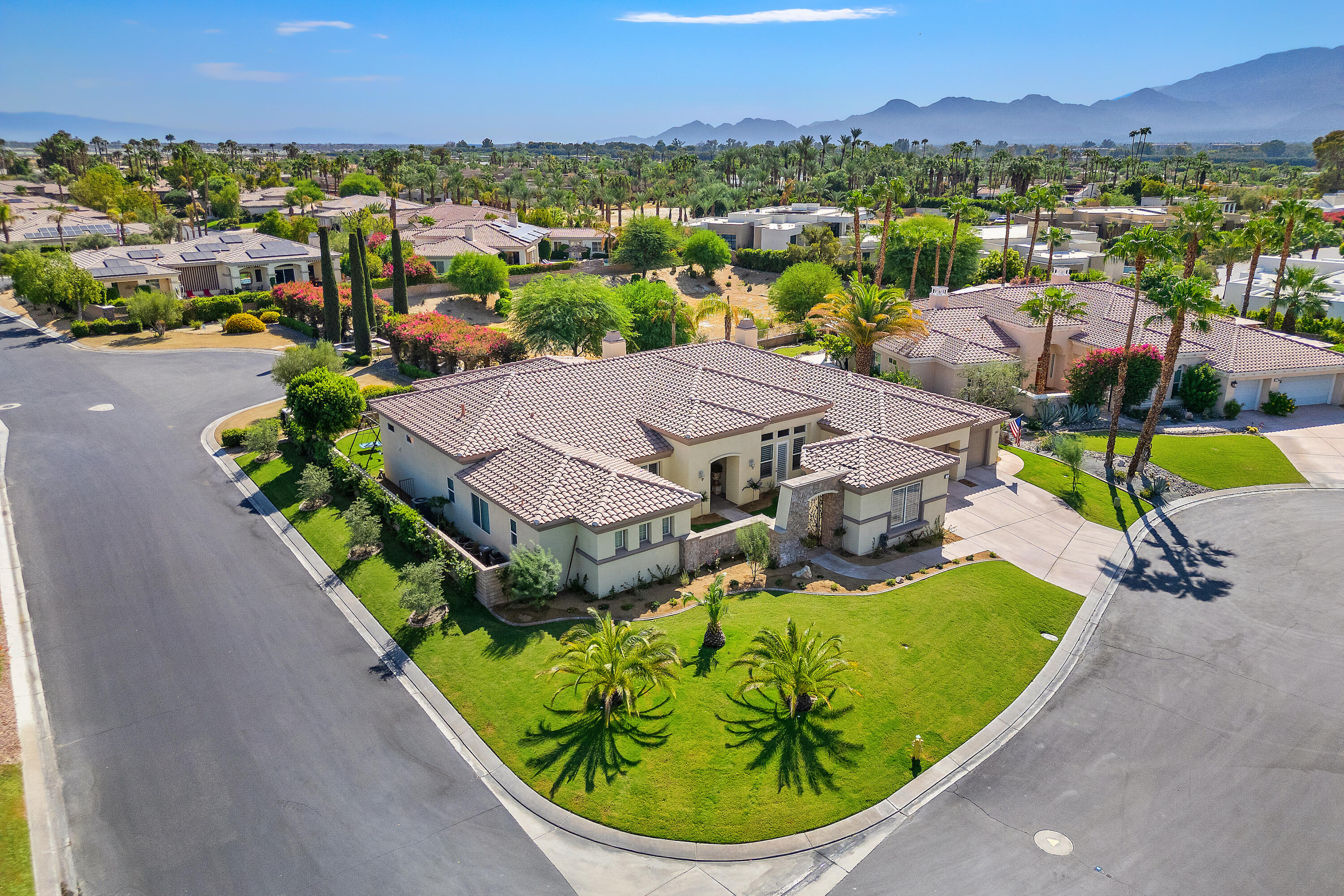 an aerial view of residential houses with outdoor space and trees