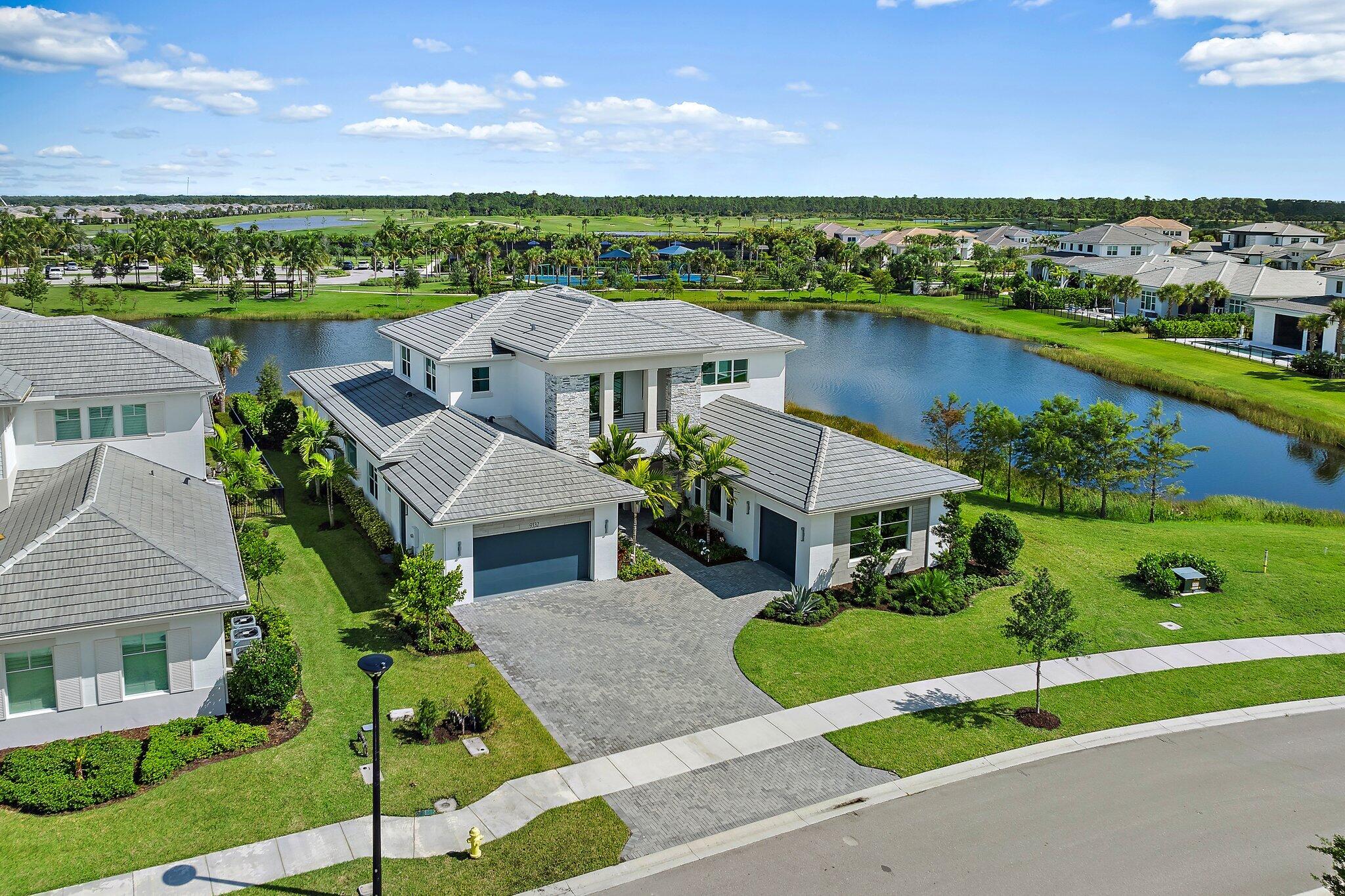 an aerial view of a house with a garden and lake view