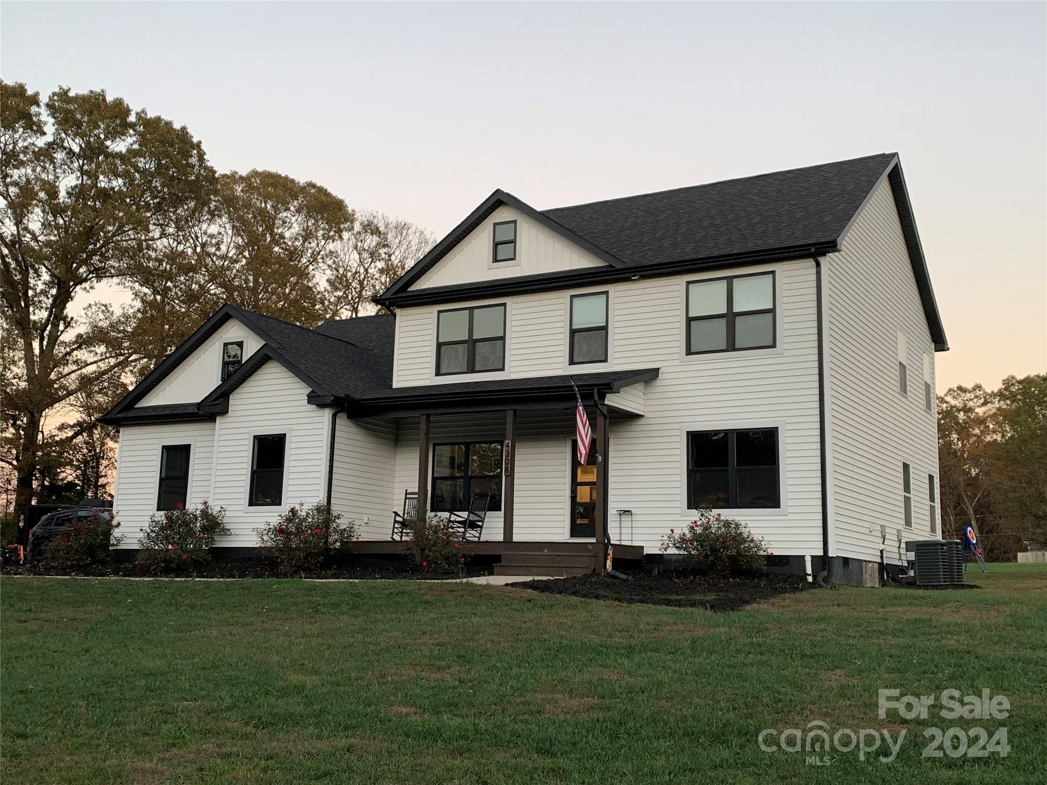 a front view of a house with a garden and yard