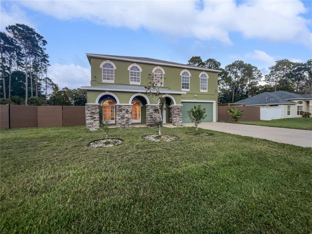 a front view of house with yard and car parked