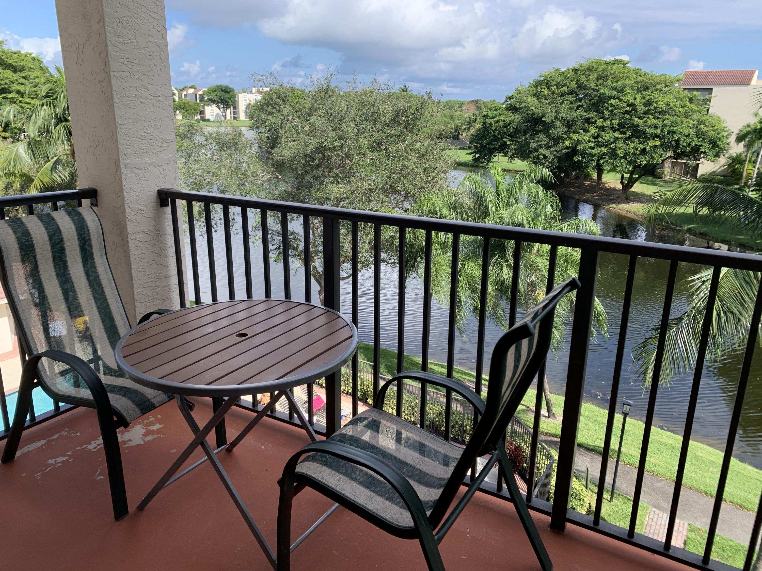 a view of a balcony with wooden floor and outdoor seating