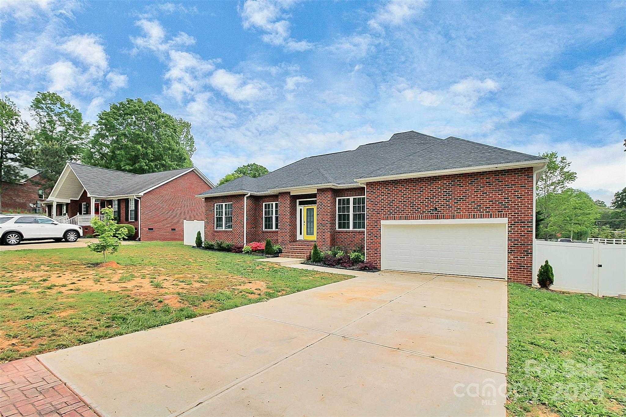 a front view of house with yard and trees in the background