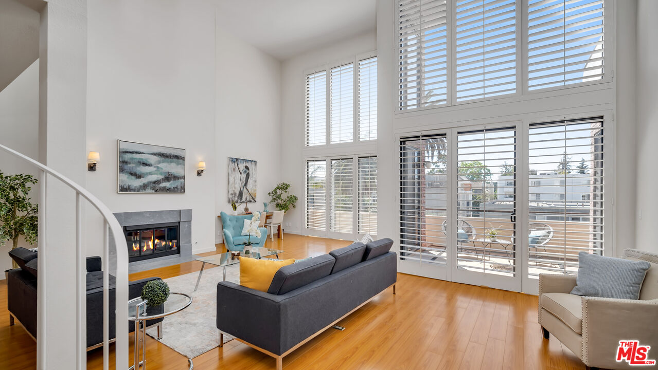 a living room with fireplace furniture and a large window