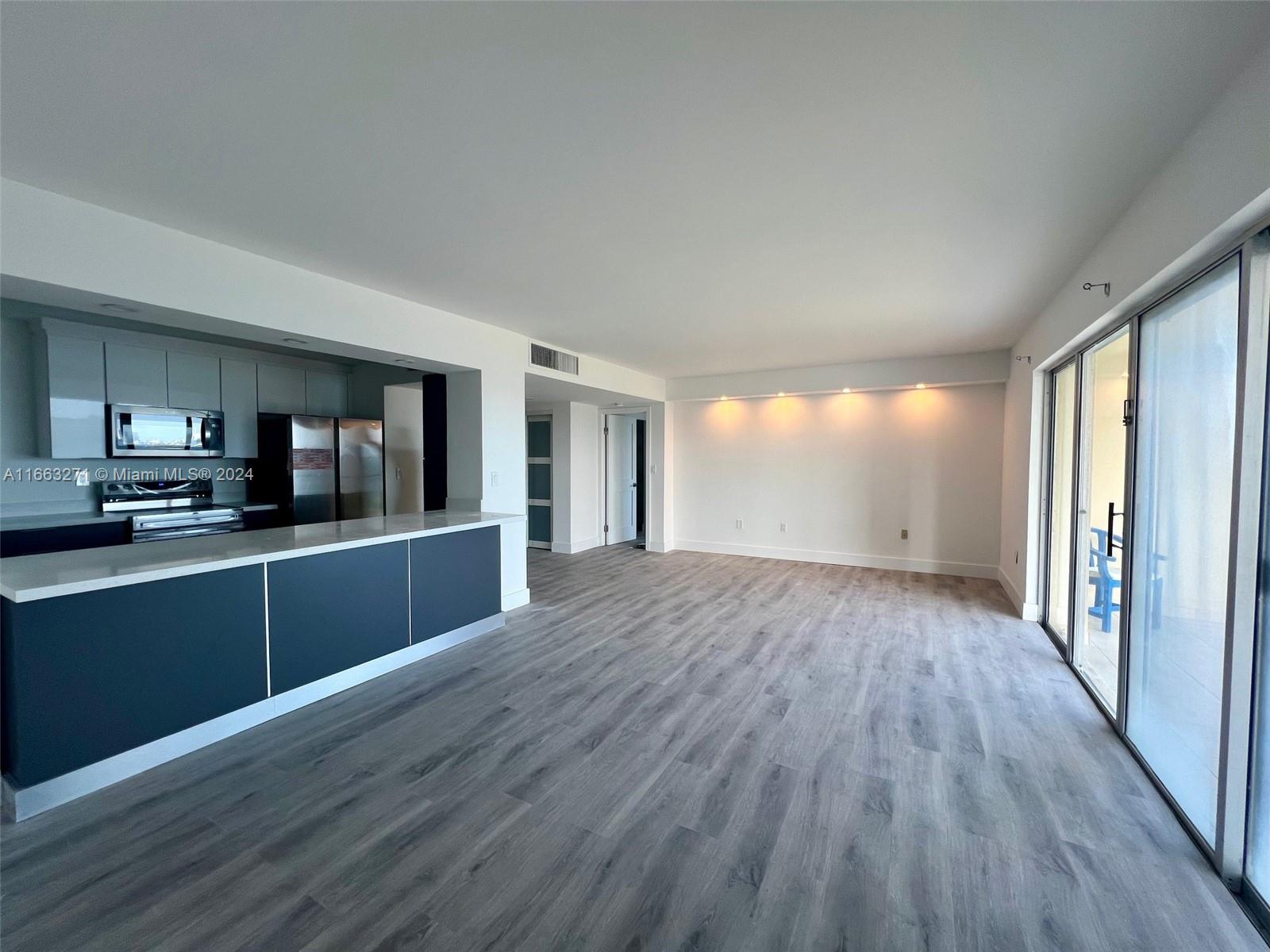 a kitchen with wooden floors and black appliances