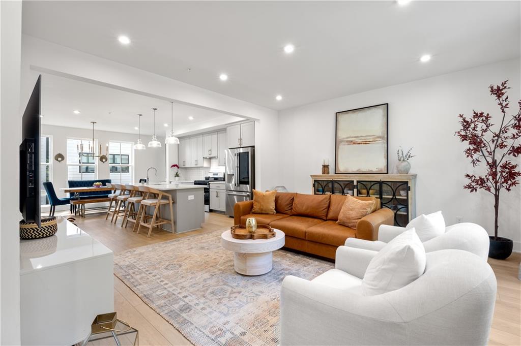 a living room with furniture and view of kitchen