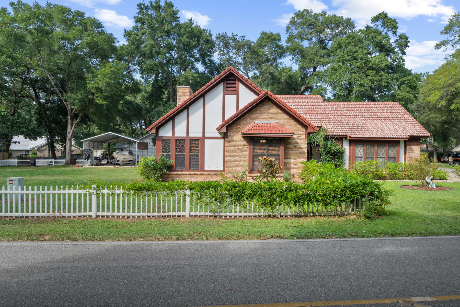 a view of a house with a yard and large trees