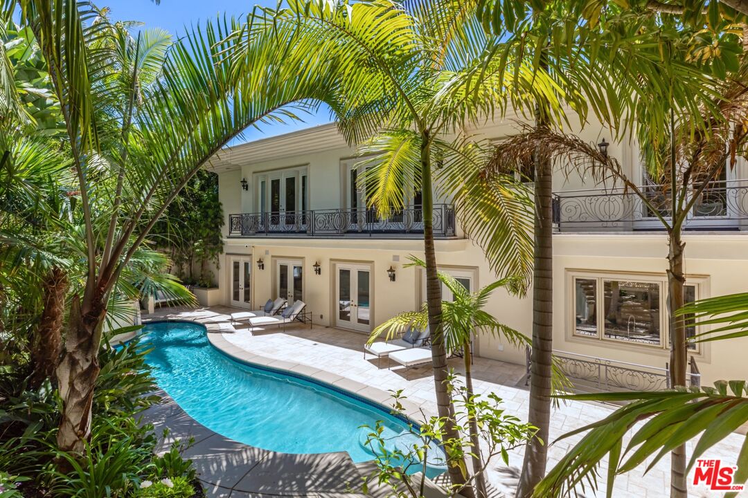 a view of a house with backyard and sitting area