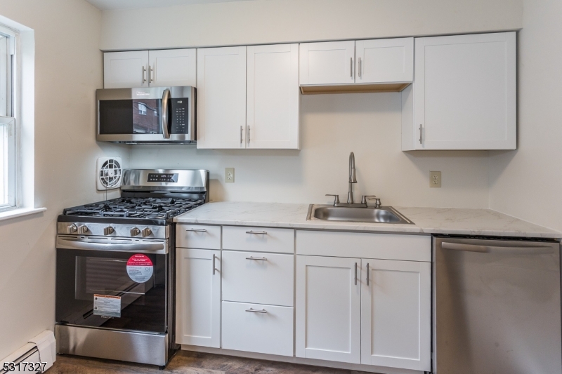 a kitchen with stainless steel appliances granite countertop a sink and a stove